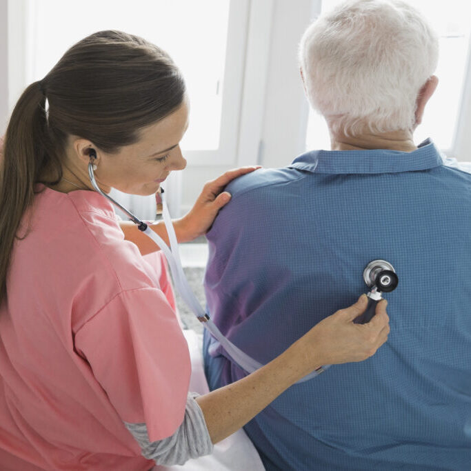 team-pic-1 Home care nurse examining man with stethoscope